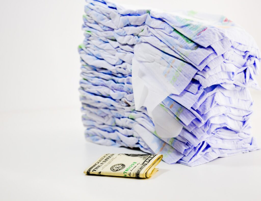 a stack of diapers with money - weekend potty training