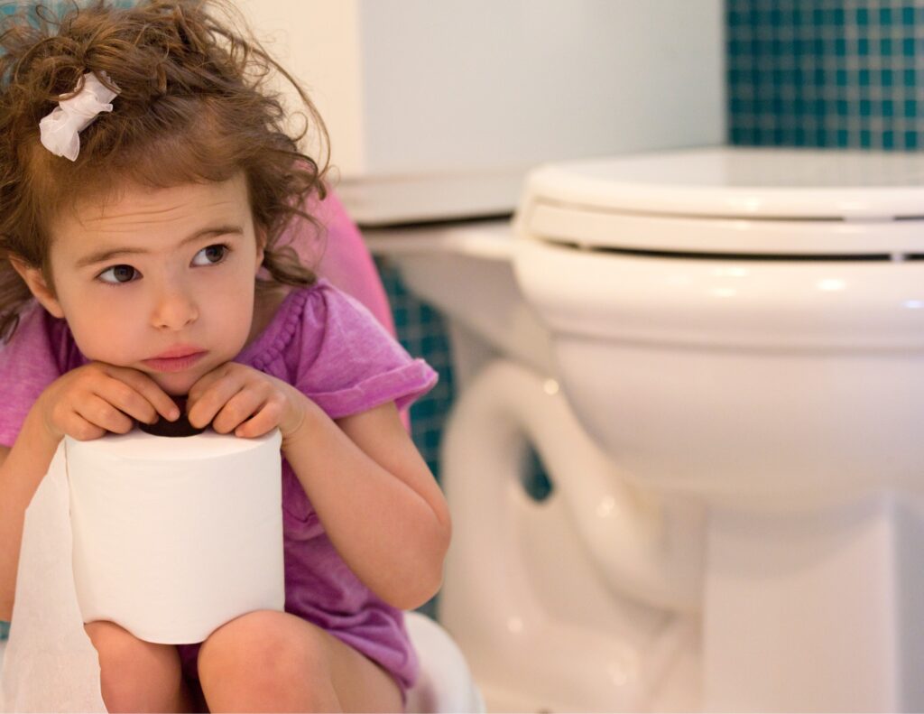 a little girl is sitting on a potty with a roll of toilet paper in her hands - weekend potty training