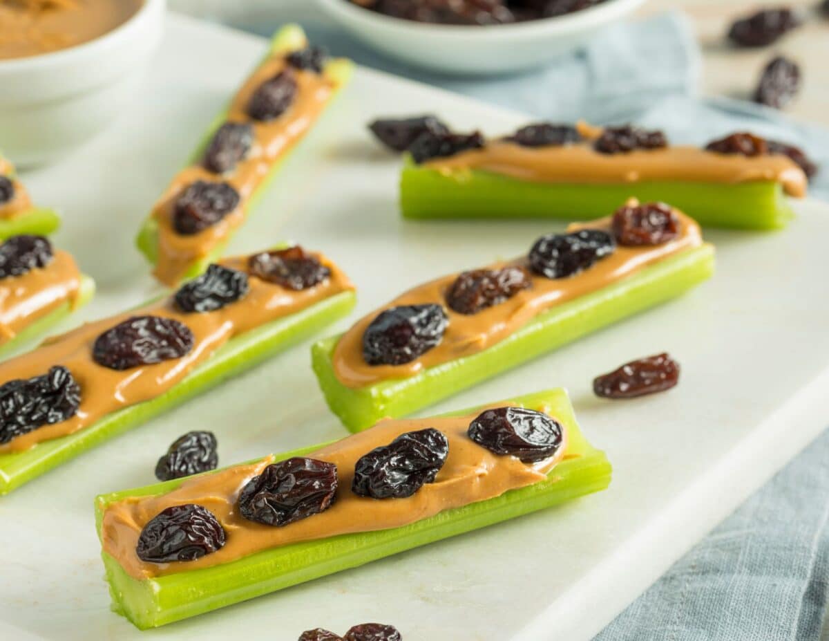 Ants on a log which are celery sticks with peanut butter and raisins added to the top- cheap healthy snack.