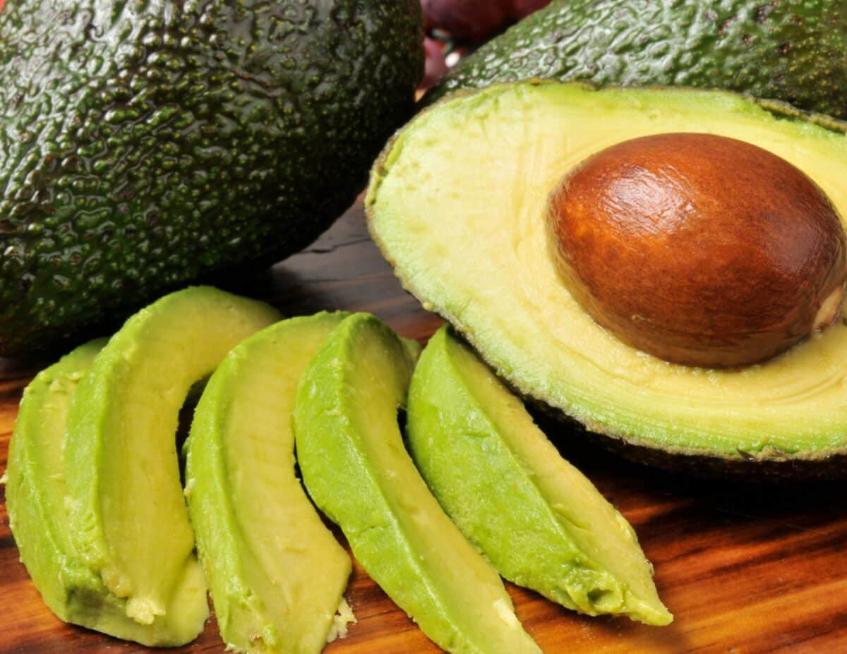 A half avocado with slices of avocado - cheapest food to buy.