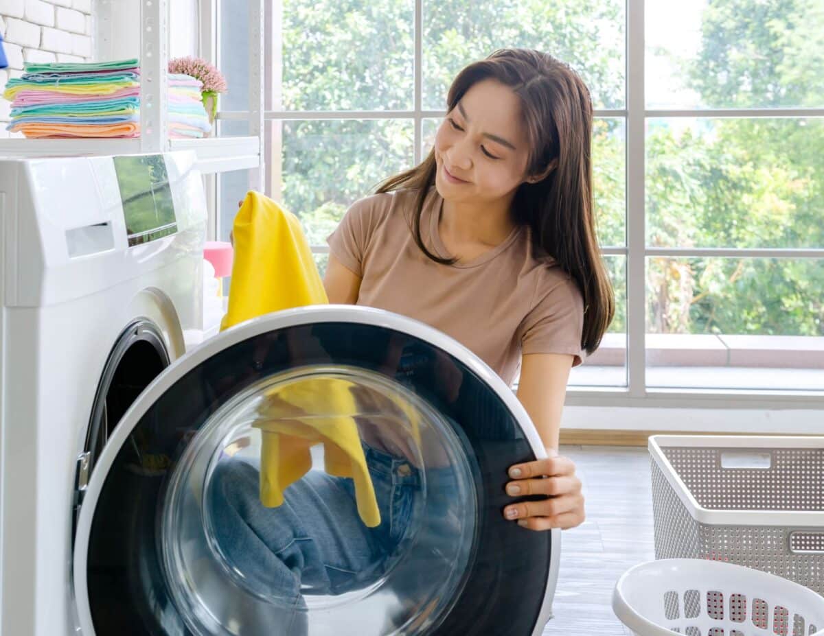 a woman is examining a towel out of the drier - homemade laundry detergent.