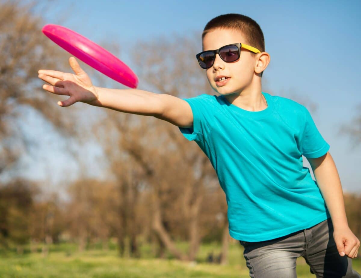A boy is catching a frisbee - backyard staycation.