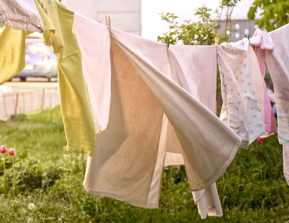 Clothes on a clothesline are blowing in the breeze - how to save money on electric bills in summer.