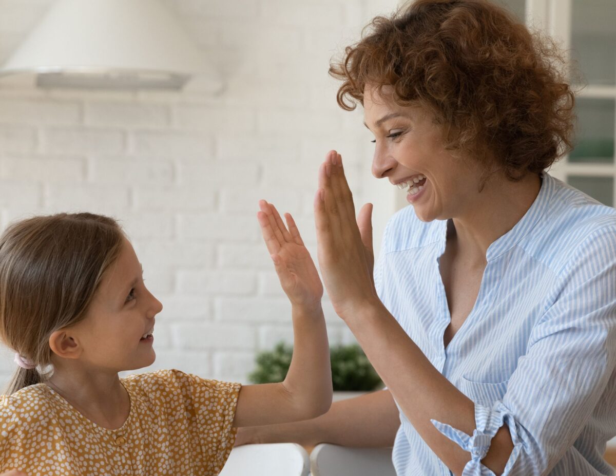 A mother is high-fiving her daughter-chores for 8-year-olds.