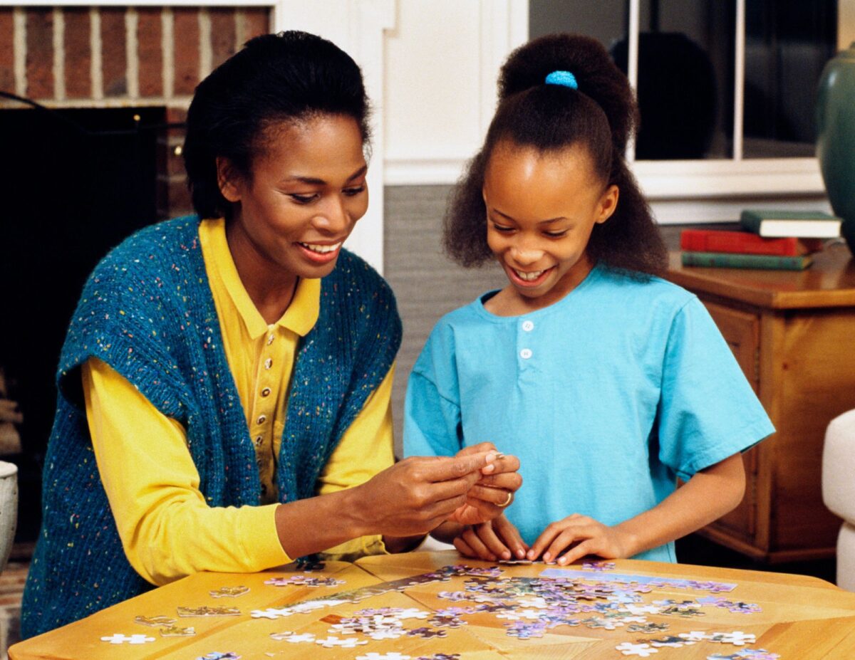Mother and daughter are doing a jigsaw puzzle together - frugal tips from the Great Depression.
