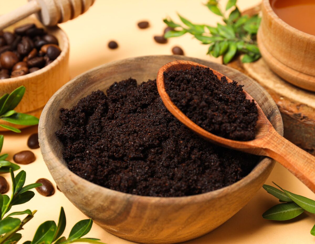 a bowl of coffee grounds with a spoonful - frugal and natural skincare routine.