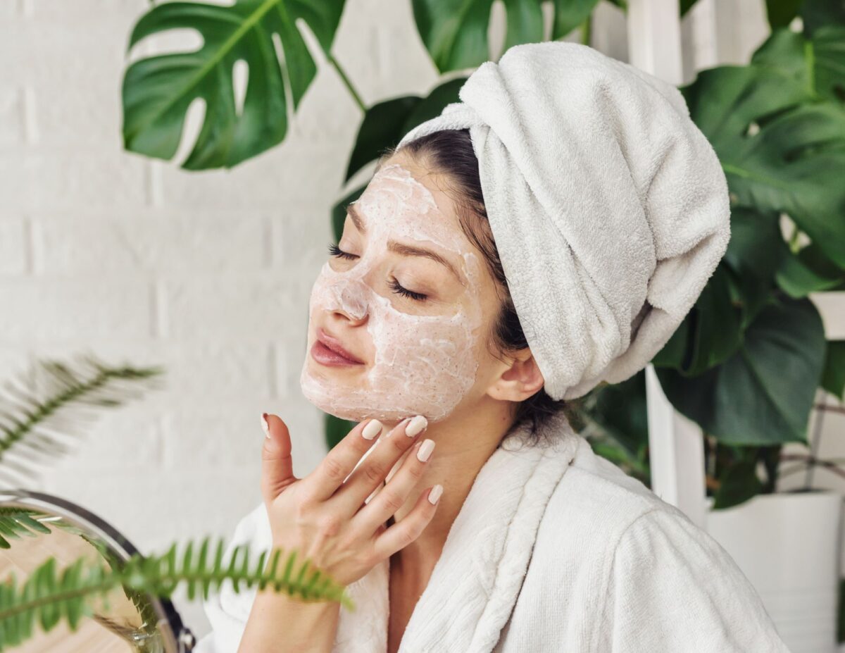 A woman is applying a white substance to her face - frugal and natural skincare routine.