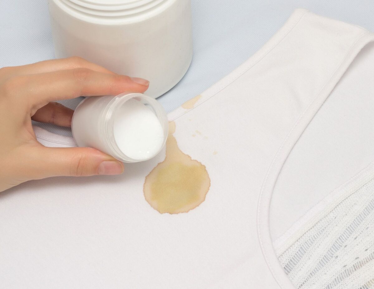 A person is about to pour some spot cleaner on a stain on a shirt - DIY natural household cleaners.
