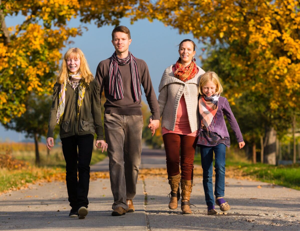 A family of four walking in the fall time - budget-friendly fall activities.