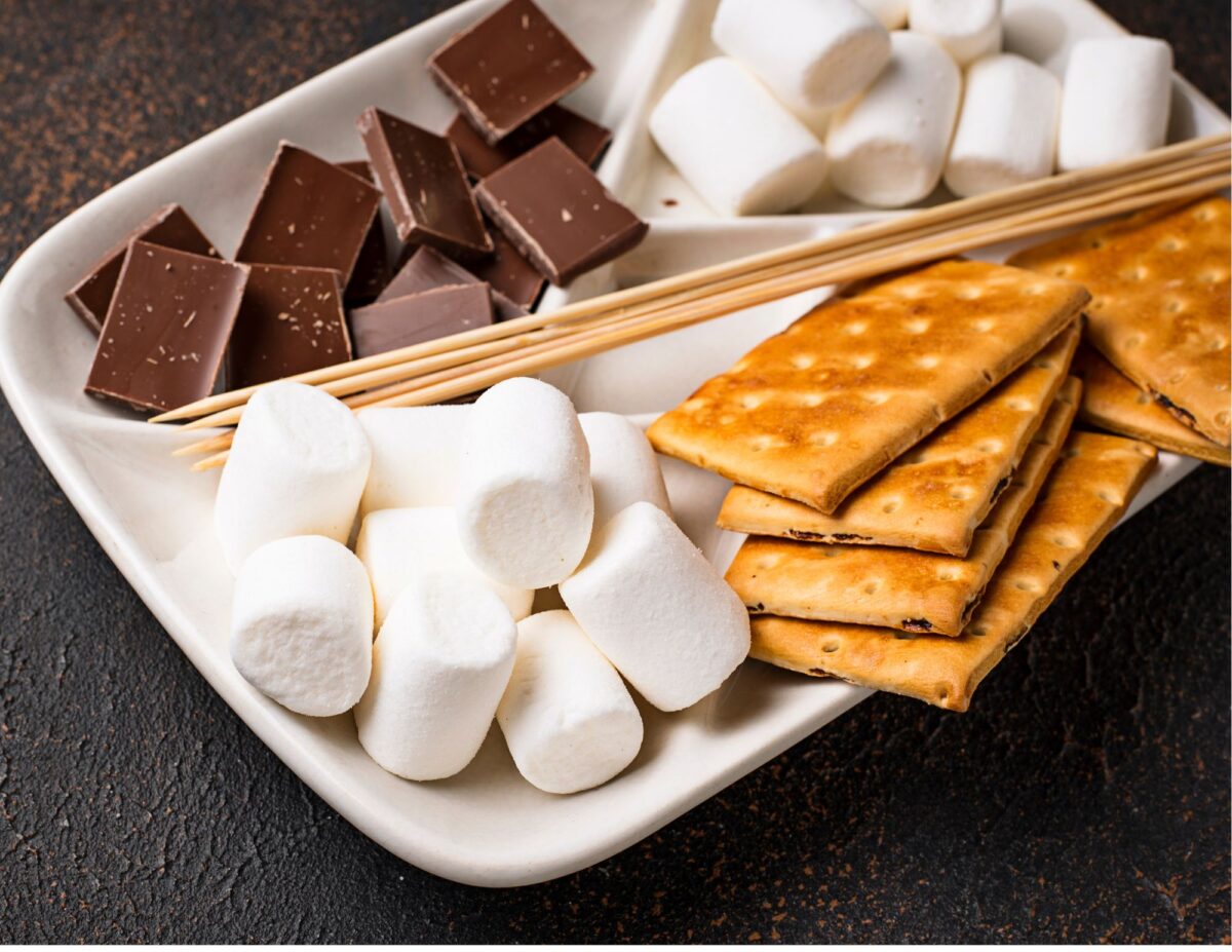 A plate with skewers, marshmallows, chunks of chocolate, and graham crackers - budget-friendly fall activities