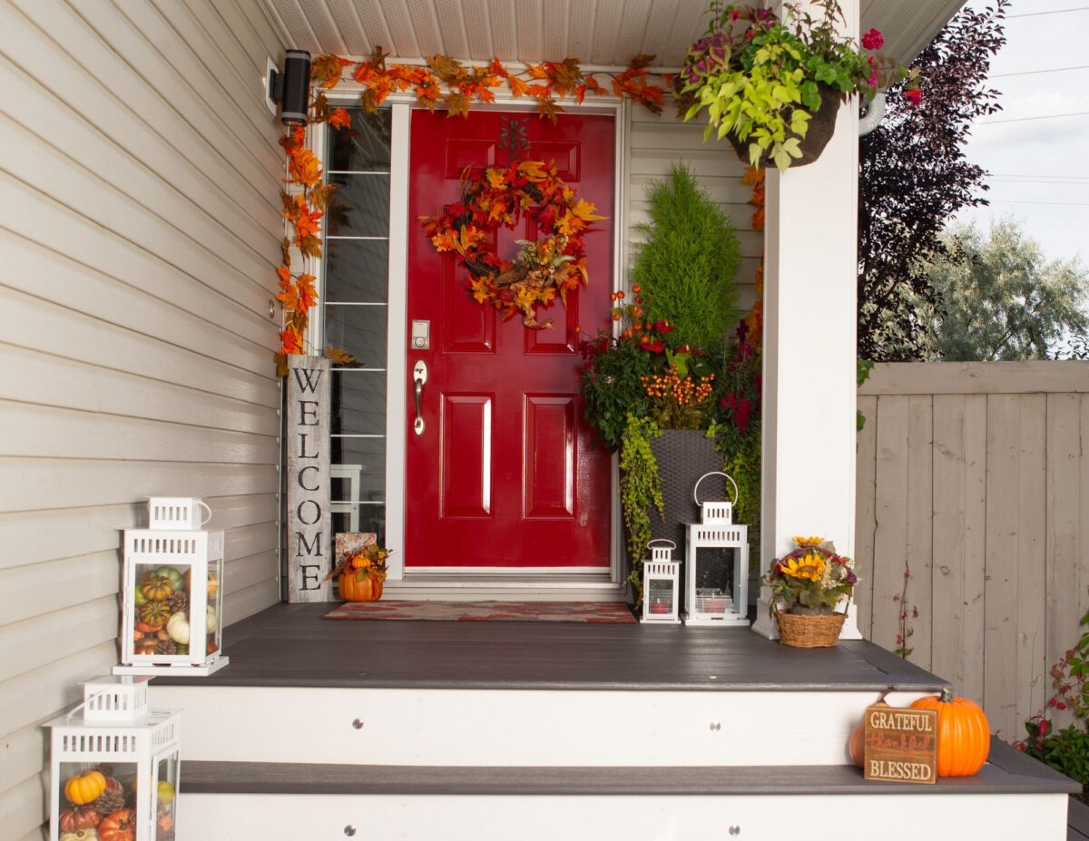 A front porch with a wreath and other fall decorations - cheap outside DIY fall decorations.