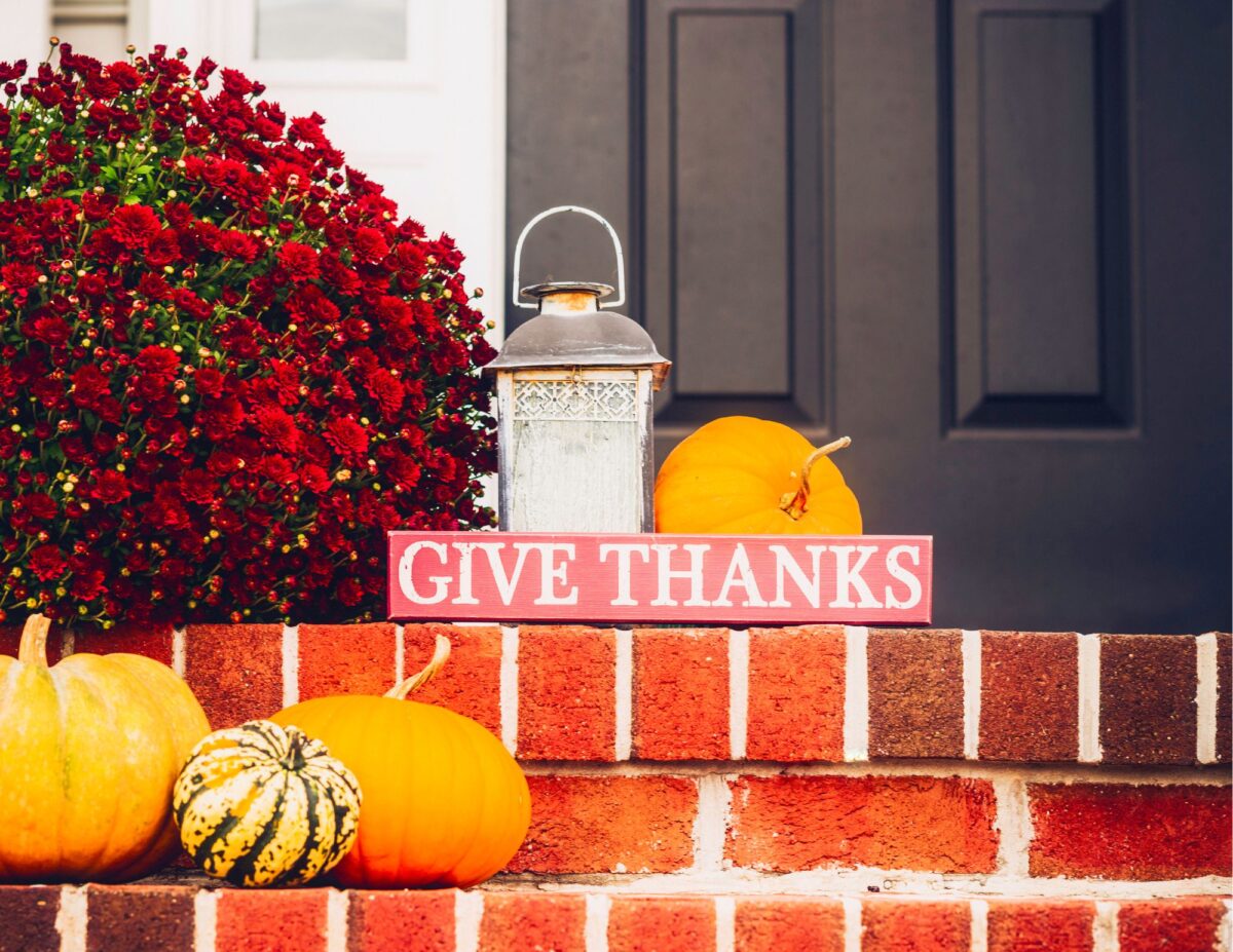 Front steps with pumpkins and a sign that says, "give thanks" - cheap outside DIY fall decorations.