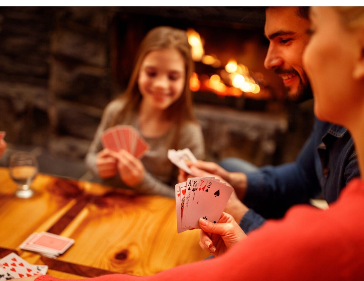 A famil is playing cards - celebrating Thanksgiving on a tight budget.