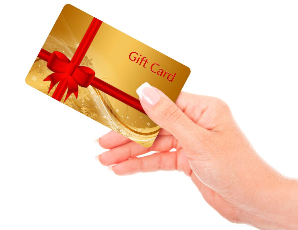 Someone holding a card with the words, "gift card" - frugal gifts for Christmas.