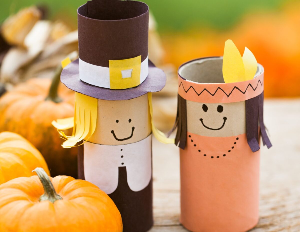 Decorations of handmade paper pilgrims with pumpkins - Ce;ebratomg Thanksgiving on a tight budget.