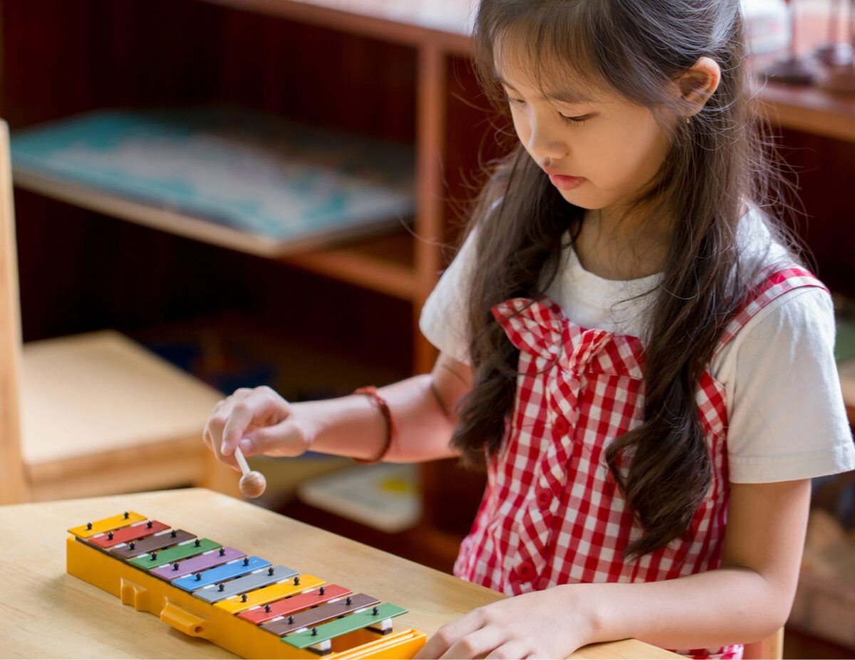 a child is playing on a xylophone - playroom on a budget.
