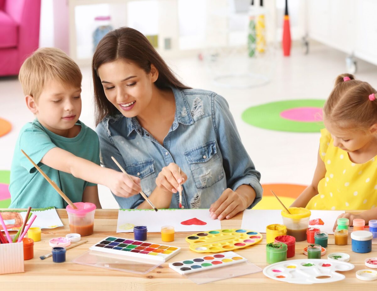 a mother and two children are painting - cheap winter indoor activities