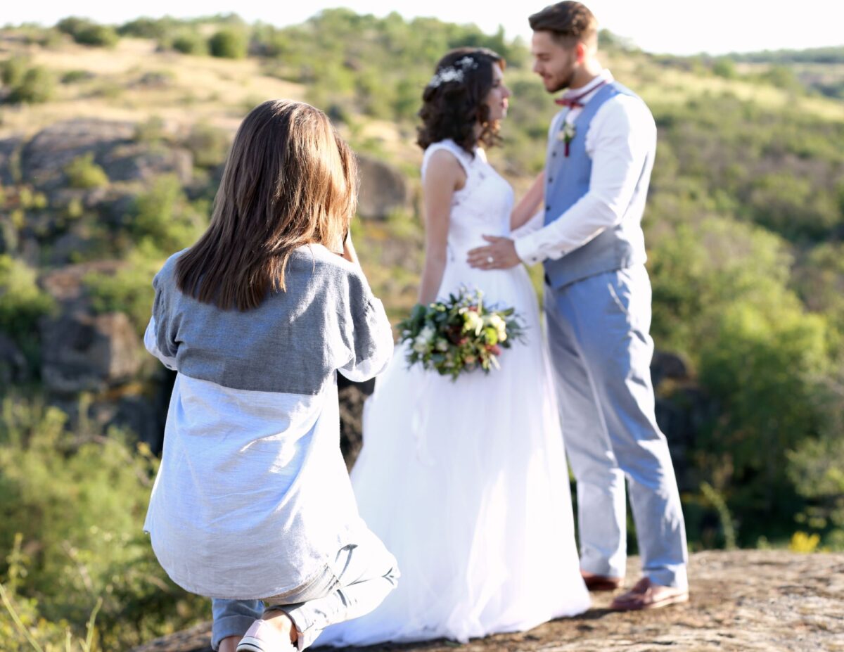 someone is taking a picture of a bride and groom  - best wedding photography on a budget