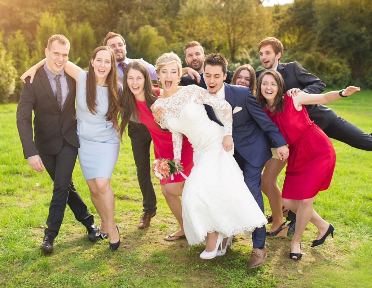 a bride and groom are posing silly with guests - best wedding photography on a budget