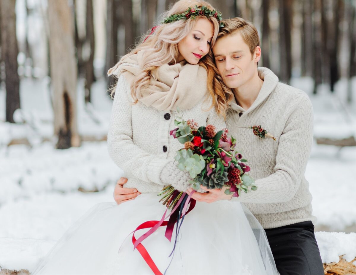 a bride and groom are outside on a winter day - outdoor wedding ideas on a budget