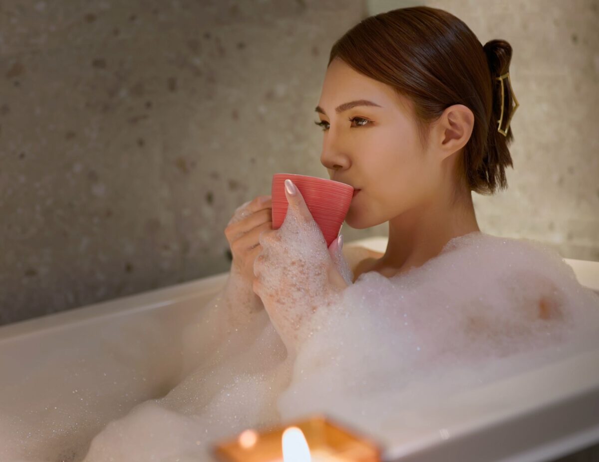 a woman is in a tub with bubbles and she is drinking something - feeling like a failure as a mom