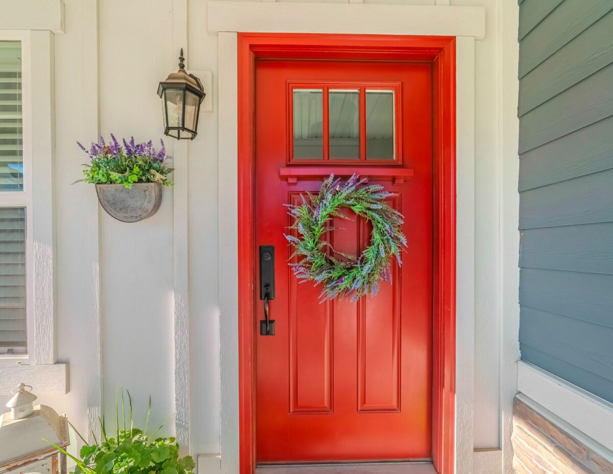 a front entrance is decorated with a wreath on the door and flowers hanging up on the wall - front door decorations for spring
