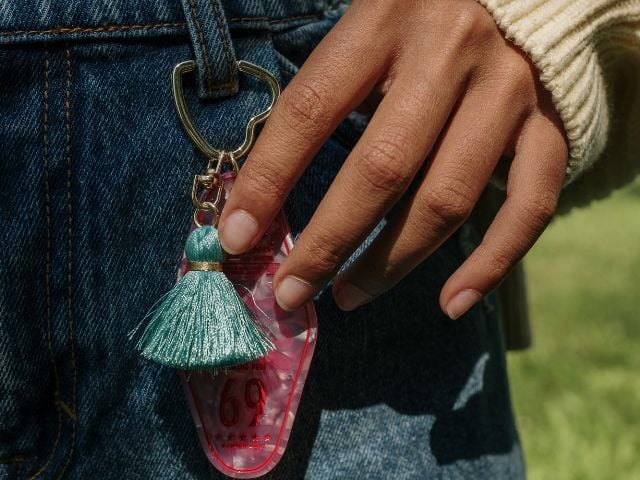 someone is touching a keychain that is attached to their pants - baby shower favors